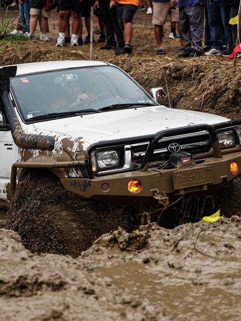 Pickup 4×4 con snorkel atravesando un pozo de barro