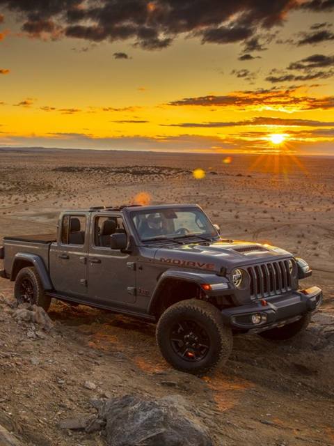Pickup 4×4 entre rocas en el desierto al atardecer